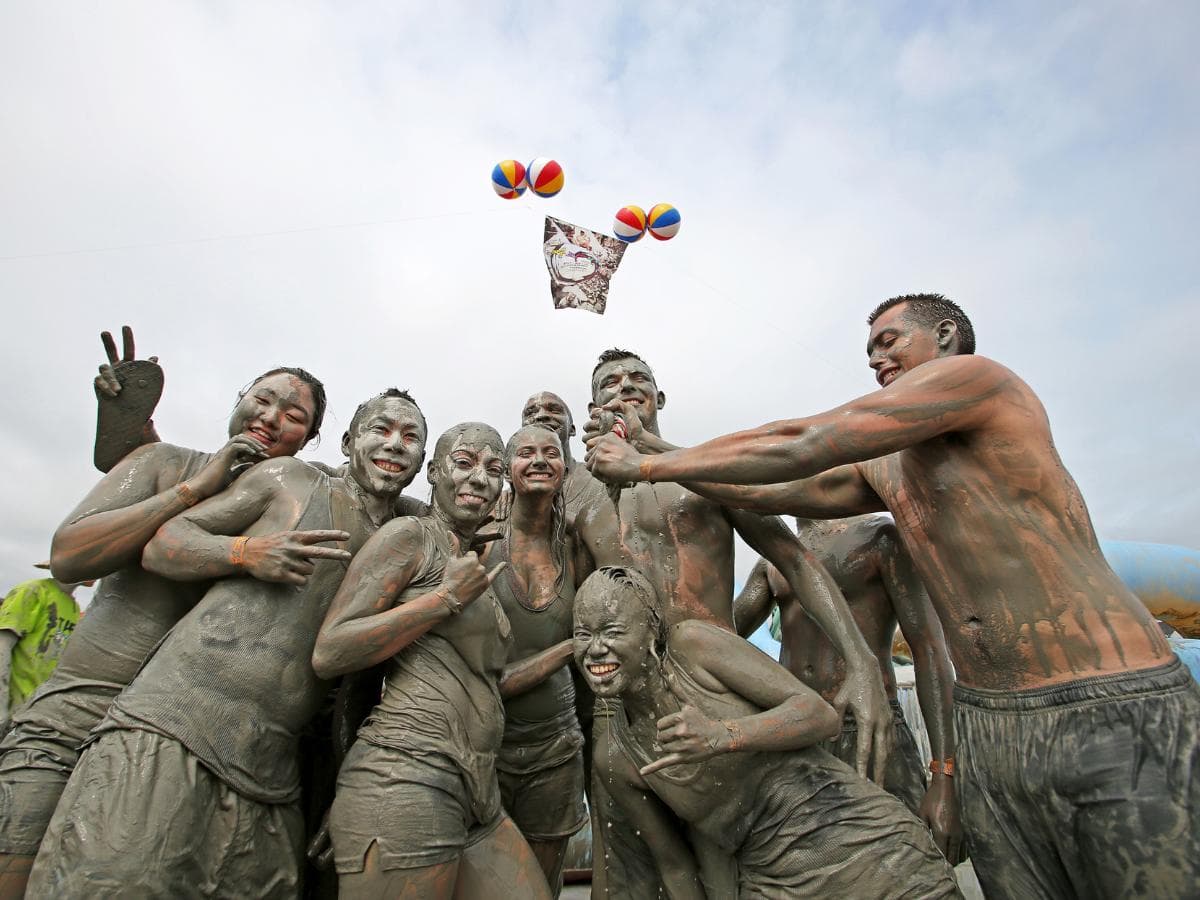 People enjoying mud all over their bodies at the Boryeong Mud Festival