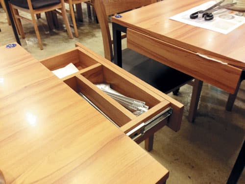 Cutlery container on open slider under table