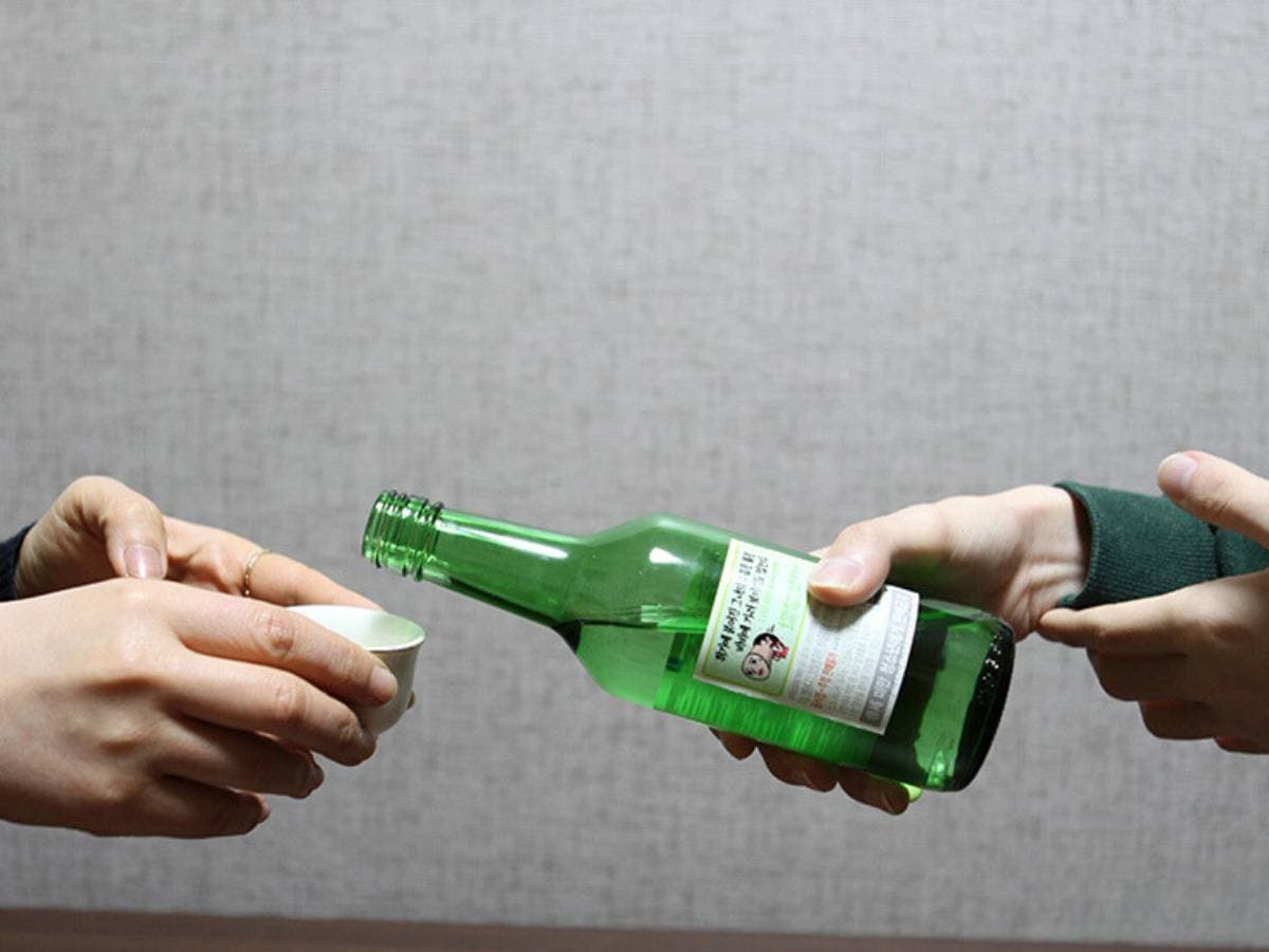 One person is pouring a drink for another person.