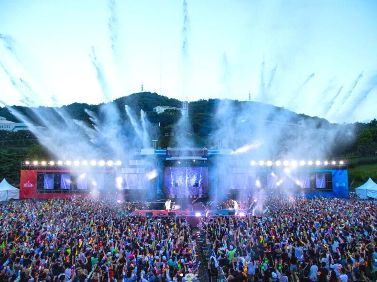 A huge amount of water is being sprayed on the audience at the Waterbomb Festival stage.