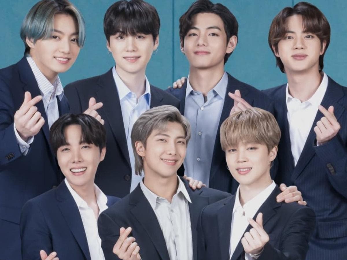 All bts members, Jungkook, Suga, V, Jin, J-Hope, RM, and Jimin, are posing finger hearts.
