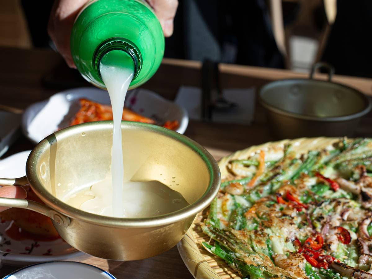 Pouring makgeolli while eating jeon